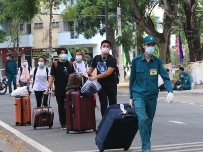 Lực lượng dân quân tự vệ Thành phố hỗ trợ người cách ly trở về nhà sau khi hoàn thành cách ly 14 ngày. (Ảnh: Thanh Vũ/TTXVN).