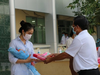 Trao quà và trao giấy xuất viện cho trường hợp mắc COVID-19 sau thời gian điều trị, tại Bệnh viện Đa khoa Sa Đéc, Đồng Tháp. (Ảnh: Chương Đài/TTXVN).