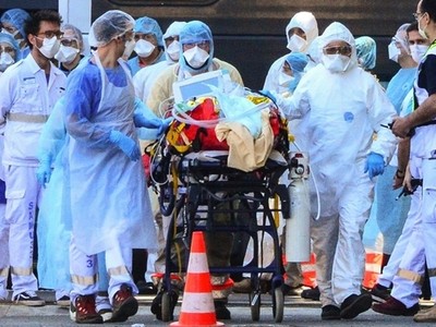 Nhân viên y tế di chuyển người nhiễm nCoV tại Pháp ngày 10/4. Ảnh: AFP.