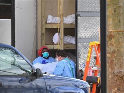 Nhân viên y tế chuyển thi thể bệnh nhân COVID-19 từ một nhà xác dã chiến tới Trung tâm y tế Do thái Kingsbrook ở Brooklyn, New York, Mỹ. (Ảnh: AFP/TTXVN).