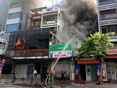 Lực lượng chức năng có mặt tại hiện trường để khống chế đám cháy. (Ảnh: TTXVN).