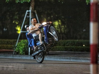Các thanh niên bốc đầu, đua xe quanh hồ Gươm. (Ảnh: TTXVN).