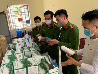 Lực lượng công an kiểm tra lô hàng khẩu trang vừa bị thu giữ. (Nguồn: TTXVN phát).