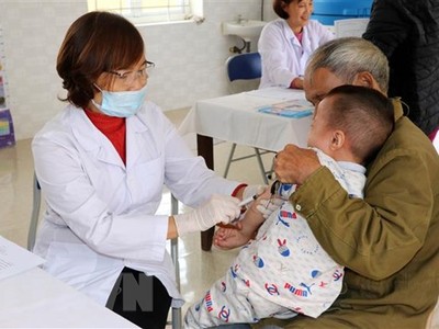 Cán bộ y tế tiêm phòng cho trẻ. (Ảnh: Nguyễn Lành/TTXVN).