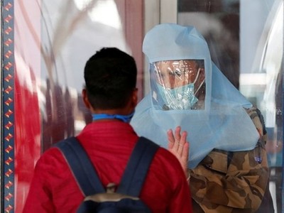 Nhân viên an ninh nói chuyện với hành khách tại sân bay ở New Delhi, Ấn Độ ngày 25/5. Ảnh: Reuters.