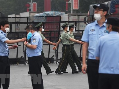 Cảnh sát gác tại lối vào chợ Tân Phát Địa ở Bắc Kinh, Trung Quốc, ngày 13/6, sau khi chợ phải đóng cửa do phát hiện ca nhiễm COVID-19 mới. (Ảnh: AFP/TTXVN).