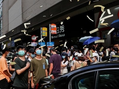 Người biểu tình tung tiền âm phủ trong cuộc tuần hành phản đối luật an ninh hôm 1/7. Ảnh: Reuters.