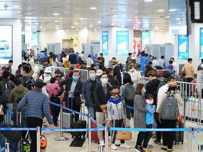 Hành khách tuân thủ việc đeo khẩu trang khi làm thủ tục chuyến bay tại Cảng hàng không quốc tế Nội Bài. (Ảnh: Phan Công/Vietnam+).