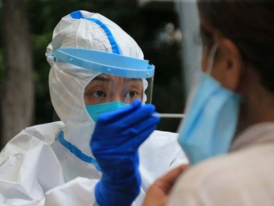 Nhân viên y tế lấy mẫu xét nghiệm nCoV tại thành phố Đại Liên, tỉnh Liêu Ninh, Trung Quốc, hôm 26/7. Ảnh: AFP.