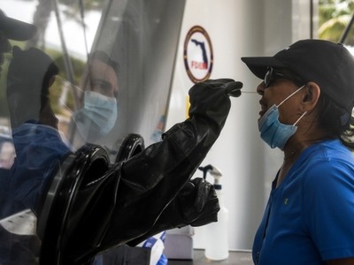 Nhân viên y tế lấy mẫu xét nghiệm cho người dân ở Miami Beach, Florida, Mỹ, hôm 24/7. Ảnh: AFP.