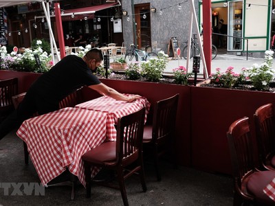 Nhân viên sửa soạn lại bàn ghế tại một nhà hàng ở New York, Mỹ. (Ảnh: AFP/TTXVN).
