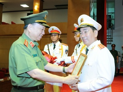 Bộ trưởng Tô Lâm trao Quyết định của Chủ tịch nước thăng cấp bậc hàm từ Thiếu tướng lên Trung tướng đối với đồng chí Trần Quốc Tỏ.