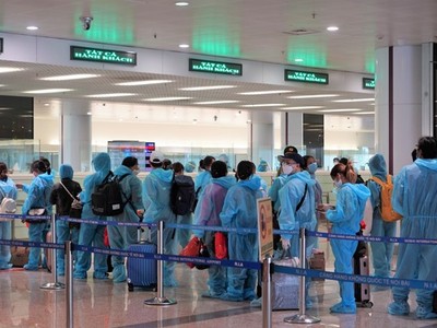 Hành khách trên chuyến bay quốc tế thương mại tới Việt Nam đầu tiên sau thời gian dài vì dịch COVID-19 làm thủ tục nhập cảnh tại sân bay Nội Bài. (Ảnh: CTV/Vietnam+).