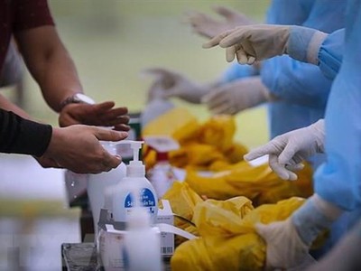 Các công dân thực hiện rửa tay bằng dung dịch khử trùng ngay khi về đến khu cách ly, trước khi được các bác sỹ phát đồ dùng cá nhân. (Ảnh: Trọng Đạt/TTXVN).