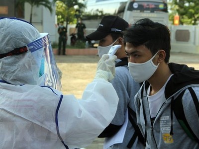 Đo thân nhiệt cho người cách ly. (Nguồn: TTXVN).