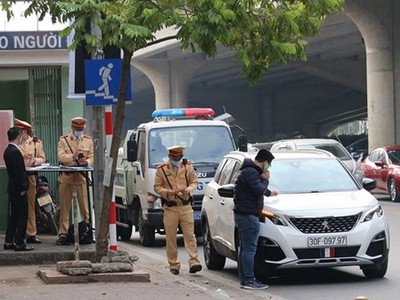 Cảnh sát giao thông Hà Nội ra quân xử lý xe ôtô dừng đỗ gây cản trở giao thông. (Nguồn: cand.com.vn).