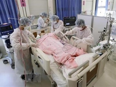 Nhân viên y tế điều trị cho bệnh nhân COVID-19 tại bệnh viện dã chiến ở Osaka, Nhật Bản. (Ảnh: Kyodo/TTXVN).