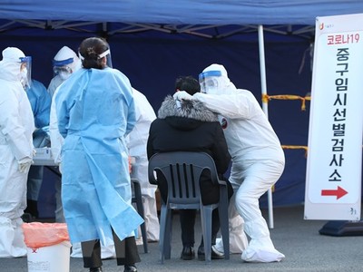 Nhân viên y tế lấy mẫu dịch xét nghiệm COVID-19 cho người dân tại Seoul, Hàn Quốc, ngày 14/12/2020. (Ảnh: THX/TTXVN).