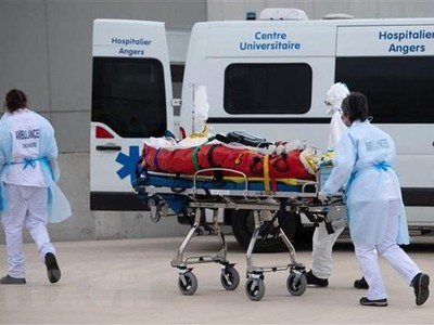 Nhân viên y tế chuyển bệnh nhân COVID-19 lên xe cứu thương tại Angers, Pháp ngày 15/3/2021. (Nguồn: AFP/TTXVN).