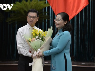 Ông Nguyễn Văn Dũng nhận hoa chúc mừng từ Chủ tịch HĐND TPHCM Nguyễn Thị Lệ.