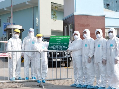 Đại diện Vietcombank, ông Nguyễn Thanh Tùng – Phó tổng giám đốc (thứ tư từ phải sang) trao kinh phí hỗ trợ phòng chống COVID-19 cho đại diện Bệnh viện K cơ sở Tân Triều: TS.BS Nguyễn Tiến Quang - Bí thư Đảng ủy, Chủ tịch Hội đồng Quản lý Bệnh Viện (thứ 3 từ trái sang), đảm bảo giãn cách và an toàn phòng chống dịch theo quy định