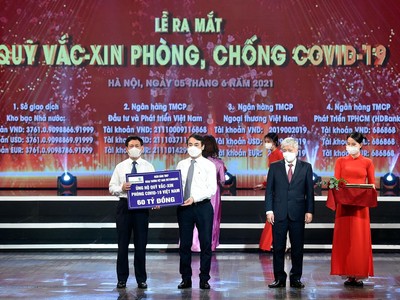 Ông Nghiêm Xuân Thành - Uỷ viên BCH Trung ương Đảng, Ủy viên BTV Đảng ủy khối DNTW, Bí thư Đảng ủy, Chủ tịch HĐQT Vietcombank (thứ 2 từ trái sang) trao biển ủng hộ 60 tỷ đồng cho Quỹ vắc-xin phòng, chống COVID-19.