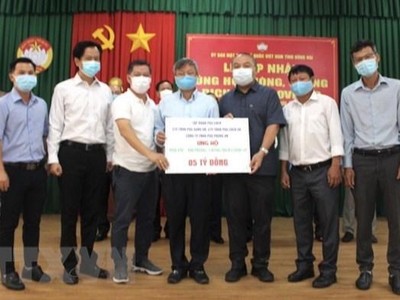 Đại diện Tập đoàn Pouchen trao 5 tỷ đồng ủng hộ Quỹ vaccine phòng, chống dịch COVID-19. (Ảnh: TTXVN phát)