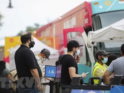 Người dân xếp hàng chờ tiêm vaccine ngừa COVID-19 tại một trạm lưu động ở New York, Mỹ. (Ảnh: THX/TTXVN)