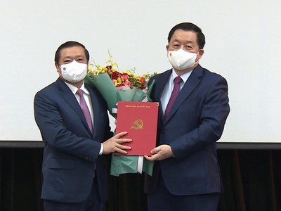 Ông Nguyễn Trọng Nghĩa trao quyết định và tặng hoa chúc mừng ông Lại Xuân Môn.