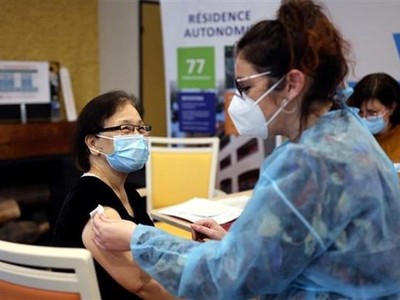 Nhân viên y tế tiêm vaccine Pfizer/BioNTech ngừa COVID-19 cho người dân tại Seoul, Hàn Quốc. (Ảnh: AFP/TTXVN).