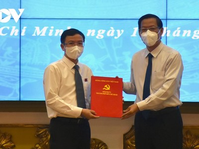 Chủ tịch UBND TP.HCM Phan Văn Mãi (phải) trao quyết định cho ông Đặng Quốc Toàn. Ảnh: Hà An.