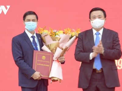 Ông Nguyễn Xuân Thắng, Ủy viên Bộ Chính trị trao Quyết định, tặng hoa chúc mừng ông Đoàn Triệu Long.