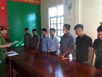 Cơ quan điều tra đọc lệnh khởi tố bảy bị can bảo kê cho đối tượng phá rừng. (Ảnh: TTXVN phát).