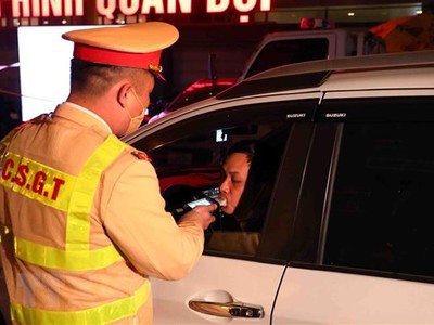 Cán bộ, chiến sỹ thuộc tổ công tác Y6/141 kiểm tra nồng độ cồn 1 tài xế ô tô tại đường Xã Đàn-Nam Đồng. (Ảnh: Phạm Kiên/TTXVN)