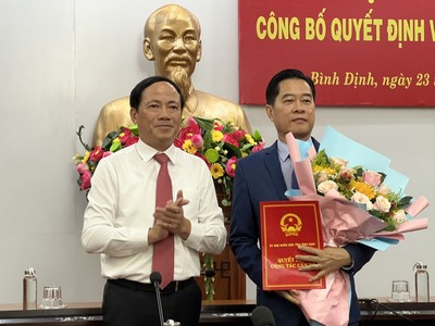 Ông Phạm Anh Tuấn, Chủ tịch UBND trao quyết định và tăng hoa chúc mừng ông Nguyễn Thành Hải, Giám đốc Sở Tài chính tỉnh.