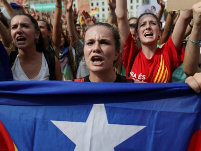 Một phụ nữ cầm cờ ly khai của Catalonia trên đường phố Barcelona hôm 2/10. Ảnh:Reuters.