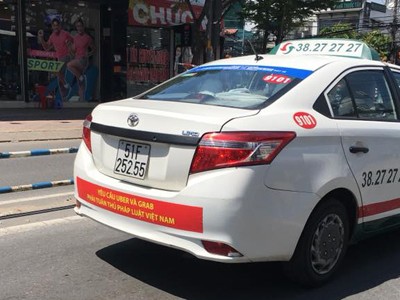Trong hai ngày cuối tuần, hàng loạt xe taxi của hãng Vinasun treo băng rôn phản đối Grab và Uber phía sau xe. Ảnh:Hồng Nhựt.