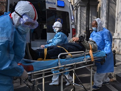 Nhân viên y tế đưa bệnh nhân nghi mắc viêm phổi cấp do virus corona ra khỏi một chung cư tại Vũ Hán, Trung Quốc ngày 30/1. Ảnh: AFP.