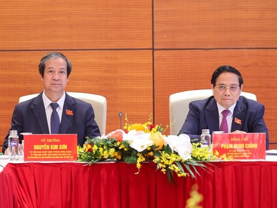 Thủ tướng Phạm Minh Chính và Bộ trưởng Bộ Giáo dục và Đào tạo Nguyễn Kim Sơn thảo luận tại tổ về các văn kiện Đại hội và dự thảo các văn kiện trình Đại hội XIV của Đảng - Ảnh: VGP/Nhật Bắc