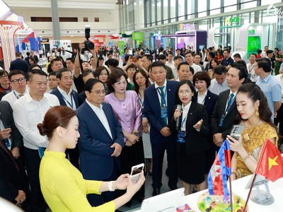Thủ tướng Chính phủ Phạm Minh Chính nghe giới thiệu về "Dịch vụ thanh toán QR xuyên biên giới" của BIDV.