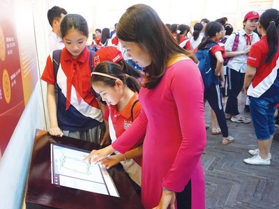 Du khách trải nghiệm màn hình diễn giải lịch sử tại Khu trung tâm Hoàng thành Thăng Long - Hà Nội.