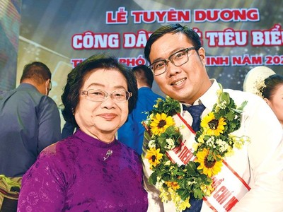 Phan Minh Tiến (bên phải) chụp ảnh cùng nguyên Phó chủ tịch nước Trương Mỹ Hoa tại Lễ tuyên dương công dân trẻ tiêu biểu TP.HCM 2020