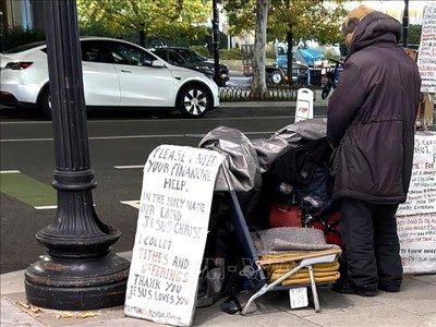 Một người vô gia cư với tấm biển cần giúp đỡ về tài chính trên một tuyến phố ở trung tâm thủ đô Washington D.C. 