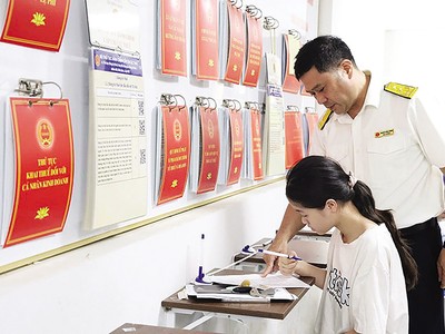 Cán bộ thuế hướng dẫn người dân làm thủ tục hành chính thuế. Ảnh: Dũng Minh 