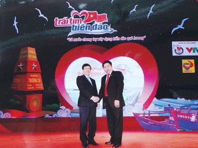 Phó thủ tướng Chính phủ Phạm Bình Minh chúc mừng doanh nhân Bùi Tùng Mậu trong Chương trình giao lưu “Trái tim biển đảo” tại Nhà hát lớn Hà Nội (10/3/2014)