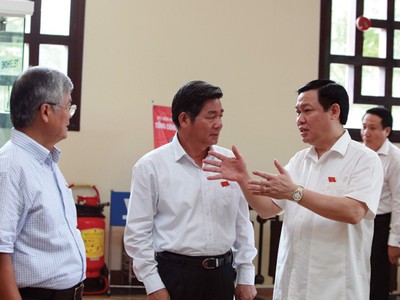 Bộ trưởng Bộ Kế hoạch và Đầu tư Bùi Quang Vinh (đứng giữa) trao đổi cùng đại biểu Quốc hội về một số vấn đề liên quan tới Dự thảo Luật 