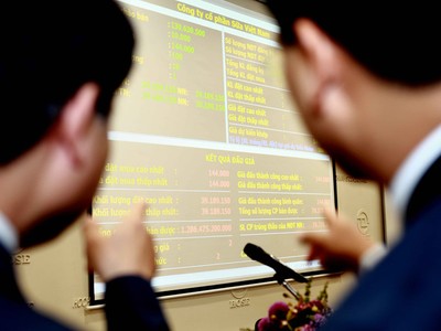 Các nhà đầu tư đang xem kết quả đấu giá cổ phiếu Vinamilk của SCIC ngày 12/12 - Ảnh: Lê Toàn