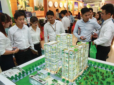 Nhân viên môi giới bất động sản giới thiệu dự án với 
khách hàng tại một hội chợ bất động sản diễn ra tại Hà Nội. Ảnh: Dũng Minh