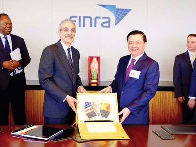 Bộ trưởng Đinh Tiến Dũng tặng quà cho Tổ chức Finra, Tổ chức giữ gìn sự liêm chính trên thị trường chứng khoán Mỹ, trong chuyến xúc tiến đầu tư tại New York, tháng 7/2015 