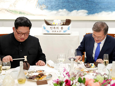 Ông Kim và ông Moon dùng búa nhỏ đập vỡ món bánh có bản đồ bán đảo Triều Tiên trên bàn tiệc. Ảnh: AFP 